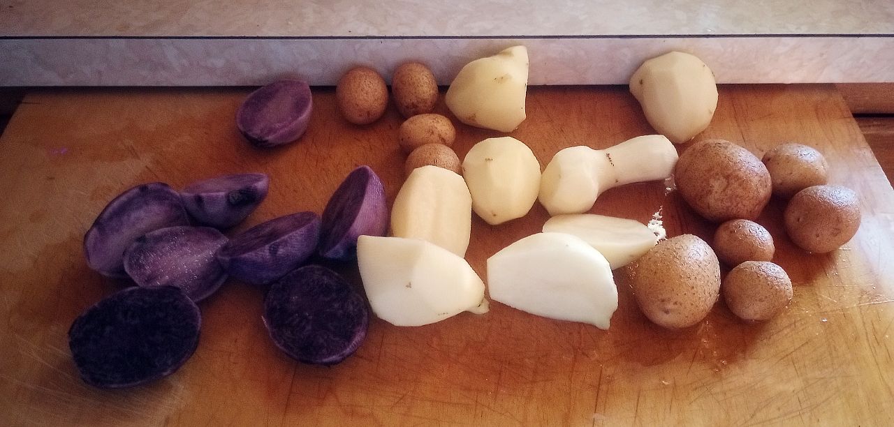 Yellow and purple potatoes on a cutting board